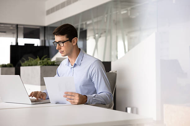 istock Serious Hispanic expert man in glasses working on document 2244669216