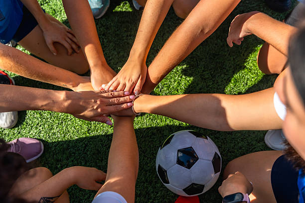 istock Women's soccer team joining hands for unity and teamwork 2244672455