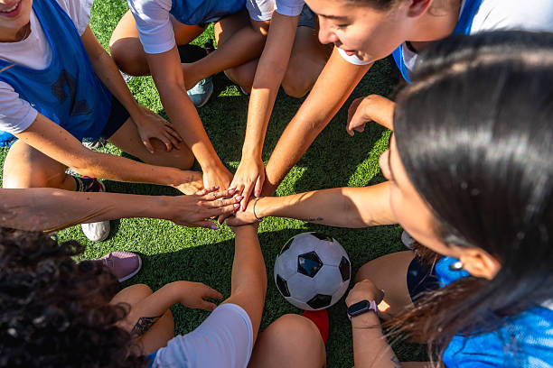 istock Women's soccer team huddling with hands stacked on artificial turf 2244672456