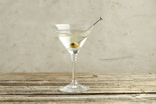 istock Martini cocktail with olive in glass on wooden table 2244675914