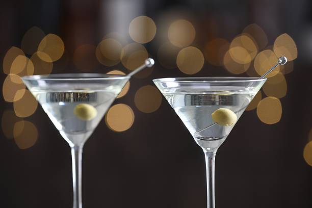 istock Martini cocktail with olives in glasses on blurred background, closeup. Bokeh effect 2244675959