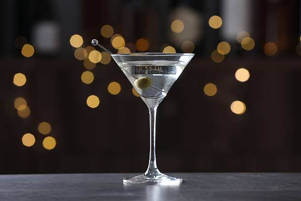 istock Martini cocktail with olive in glass on grey table against blurred background. Bokeh effect 2244676009
