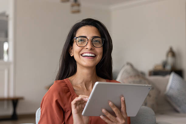 istock Cheerful beautiful Hispanic woman in stylish eyewear using digital tablet 2244678466