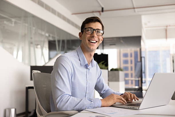 istock Cheerful handsome young business leader man typing on laptop 2244680740