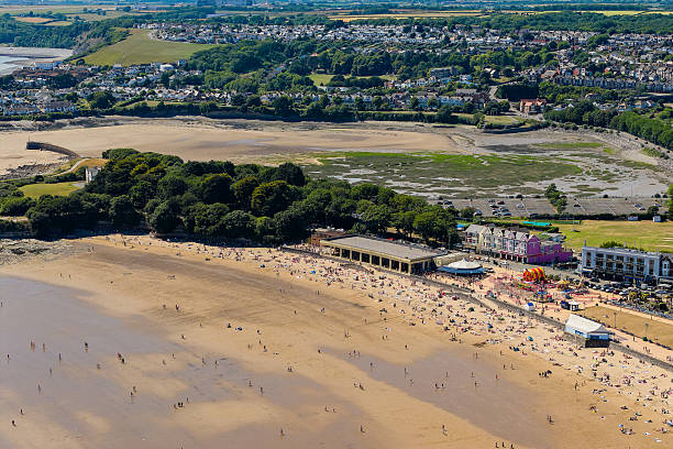 Vast sandy beach at low tide with crowds of people enjoying a hot summer day in the UK