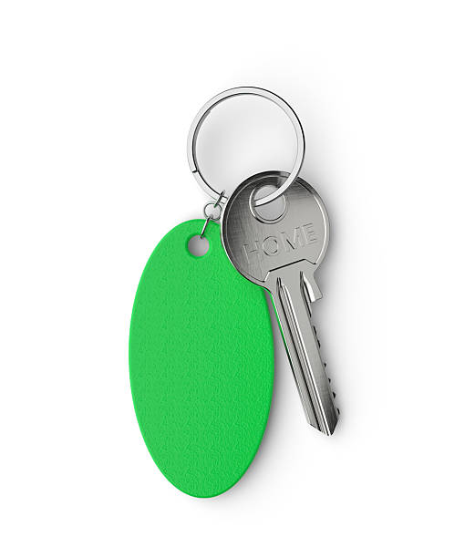 Keychain Plastic key holder in different colors with white background and various papers and a keyboard in the concept of organization and order in companies.