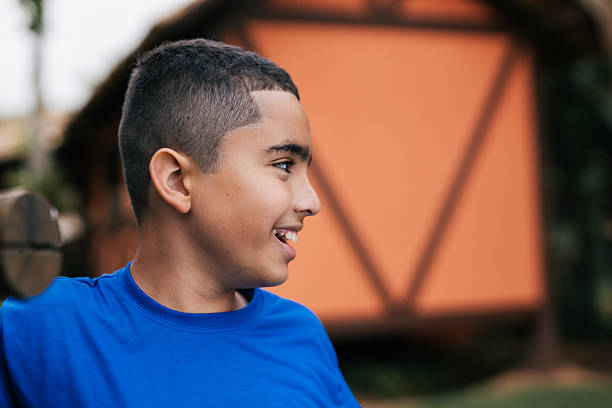 Smiling child leaning on wooden fence