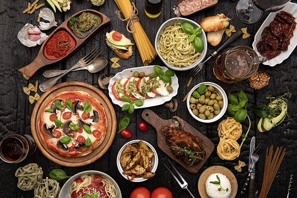 istock Rustic Italian dinner with pizza, pasta and caprese salad on dark wooden table 2244684777