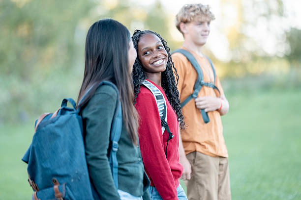 istock Three Teens With Backpacks Smiling On A Sunny Outdoor Trail With Friends 2244685576