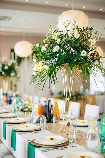 istock Elegant floral decorations on dining tables prepared for celebration, beautiful flower arrangements creating festive and romantic atmosphere 2244687361