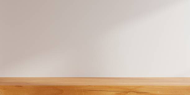 istock Minimalist interior featuring a clean wooden shelf against a soft beige wall, illuminated by natural light- 3D rendering 2244687804