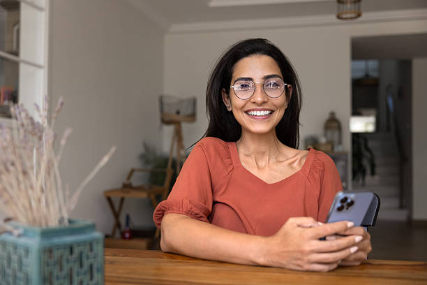 istock Happy smartphone user woman sitting at work table at home 2244688114