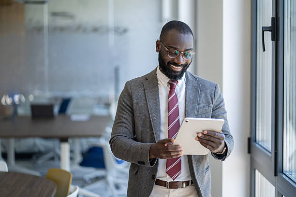 istock Smiling businessman using digital tablet in modern office 2244688137