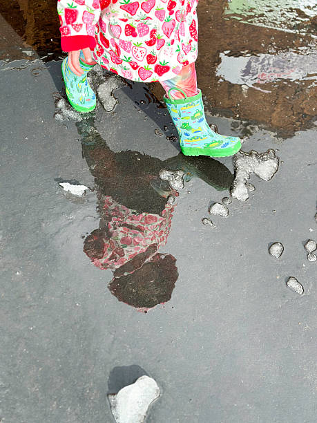 Cute toddler playing outside I the rain in a beautiful setting