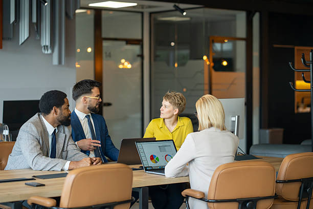 istock Business people working on laptops in modern office 2244690299