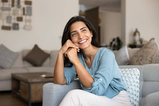 istock Cheerful beautiful young Hispanic woman sitting on comfortable couch 2244690531