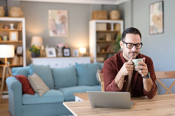 istock Man Enjoying Coffee While Working on His Laptop at Home 2244694240