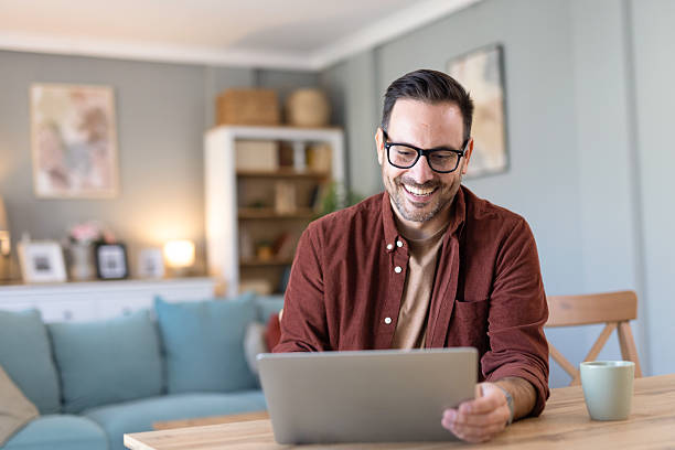 Happy Man Using Laptop with Cup, Enjoying Cozy Ambiance