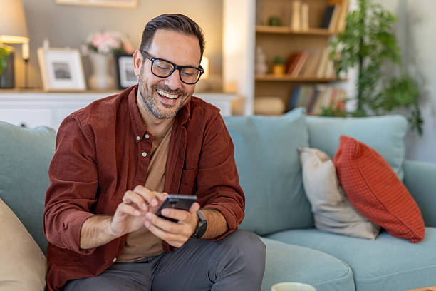 istock Man joyfully enjoying his smartphone while relaxing at home 2244694265