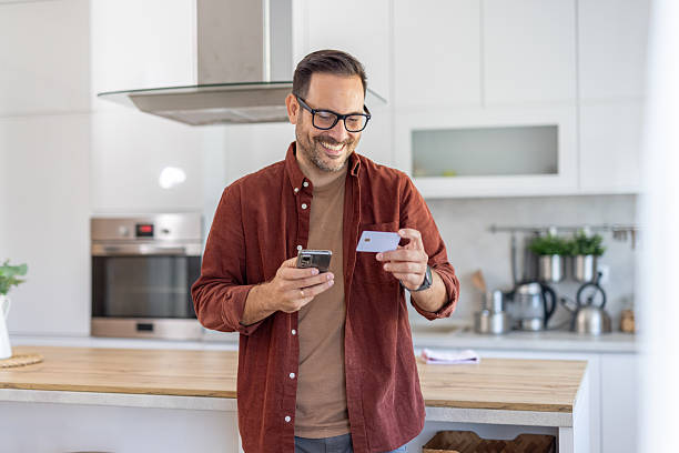 istock Happy man using a smartphone with a credit card 2244694276