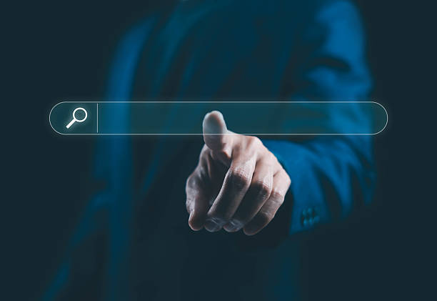 istock Businessman pointing at a blank virtual search bar on a dark background symbolizing online search digital marketing, technology innovation, internet browsing and modern business communication concept. 2244700786