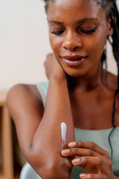 istock Black Woman Moisturizing Dry Elbow Skin with Cream. 2244701059