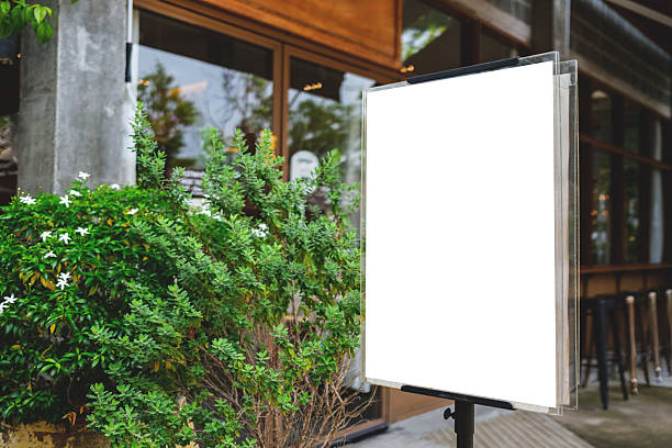 istock Blank white signage mockup stand placed outside a cafe or restaurant. Perfect for inserting text and promotion or advertisement design. 2244703653
