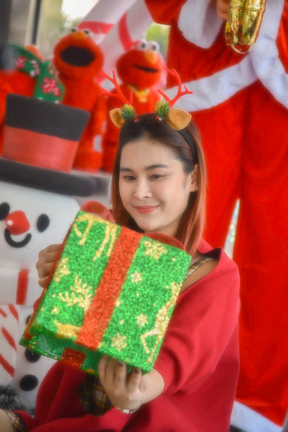 istock Happy woman decorating Christmas gift box 2244703875