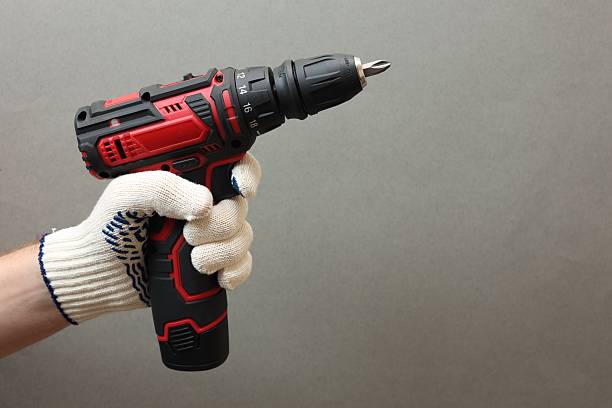 istock Handyman holding electric screwdriver on grey background, closeup. Space for text 2244711977