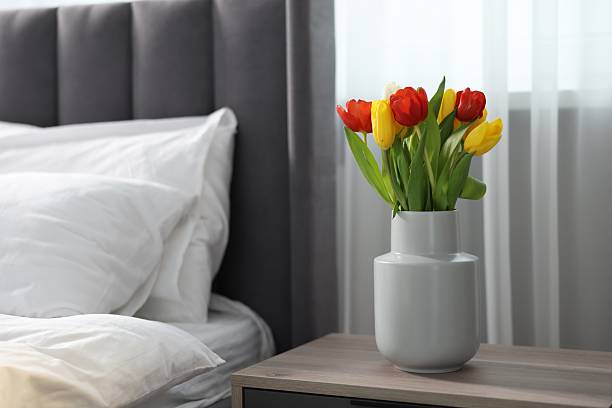 istock Beautiful tulips in vase on bedside table indoors 2244715842