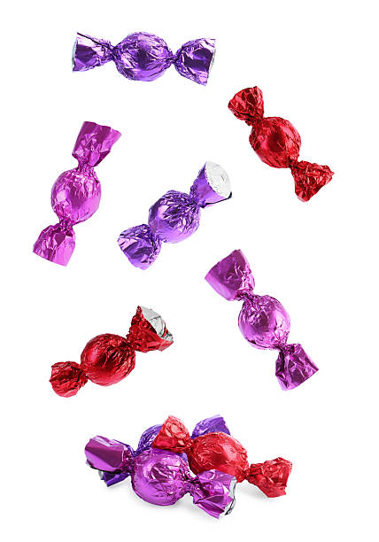 istock Tasty candies in bright wrappers falling on white background 2244718365