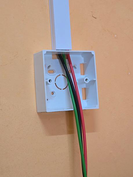 istock Electrical wiring installation with exposed cables inside a wall-mounted junction box during a renovation or maintenance process 2244724069