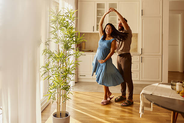 istock Carefree pregnant couple having fun while dancing at home. 2244725134
