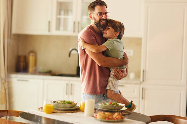 istock Carefree single father and son embracing in dining room. 2244725339