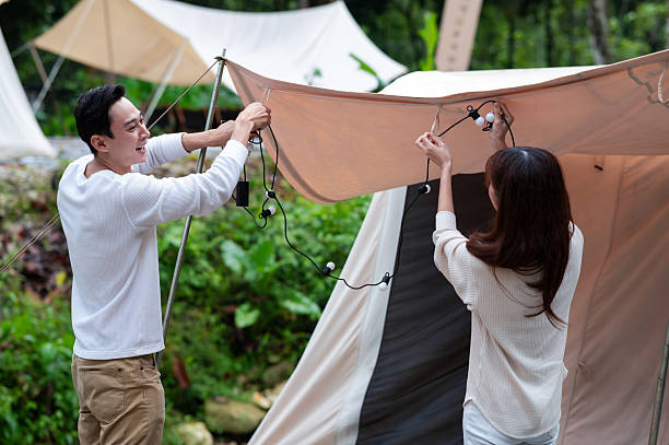 istock Asian couple setting up the camping tent and get ready for their adventurious outing in the lush forest 2244725861
