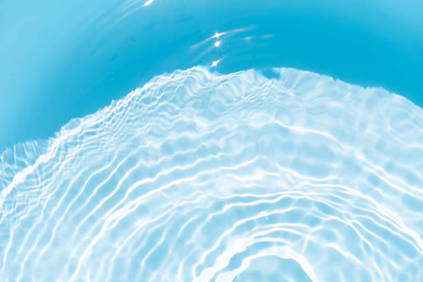 istock Blue water with ripples on the surface. Defocus blurred transparent blue colored clear calm water surface texture with splashes and bubbles. Water waves with shining pattern texture background. 2244726710