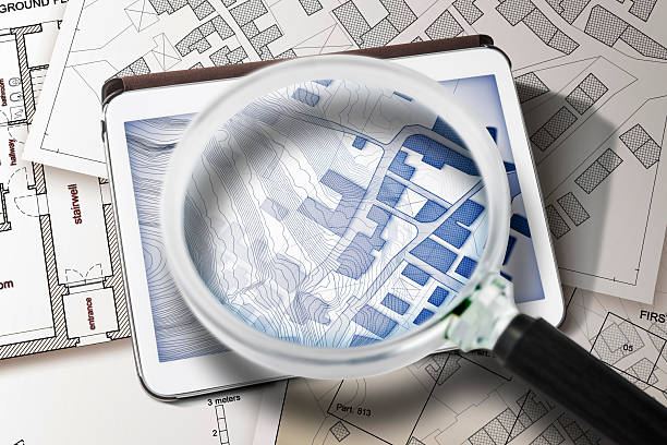 istock Imaginary cadastral map of territory with buildings and land parcel - concept with a digital tablet and magnifying glass 2244732063