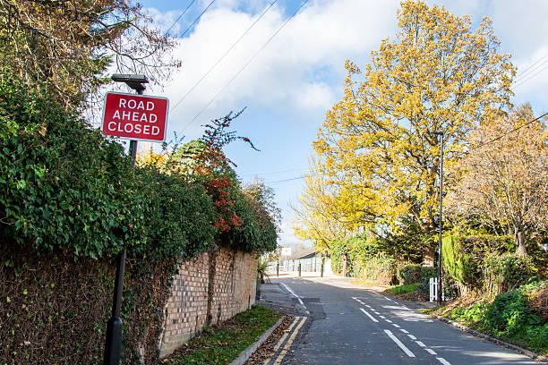 istock Red Road Ahead Closed Sign Beside Road 2244734733
