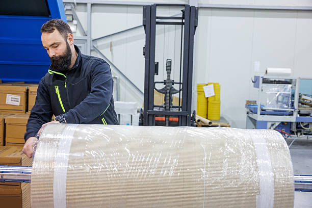 istock Man working in production and distribution industry, unwrapping bale for processing 2244736648