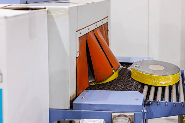 Electrical insulation tape rolls packed coming out of the conveyor machine, small-scale business manufacturing and warehouse