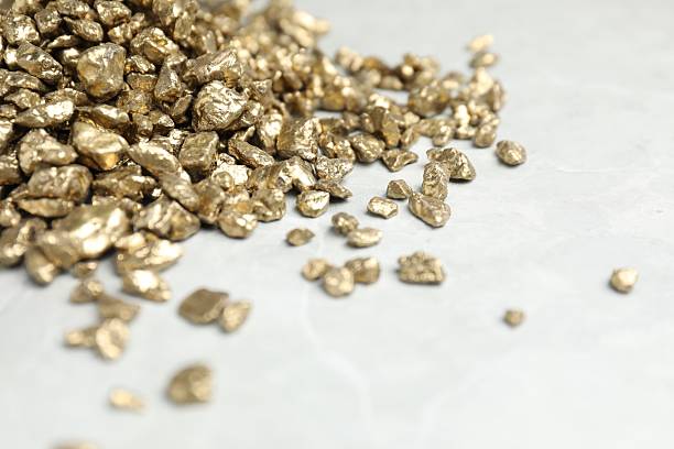 istock Gold nuggets on grey marble table, closeup. Space for text 2244738494