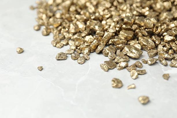 istock Gold nuggets on grey marble table, closeup. Space for text 2244738495