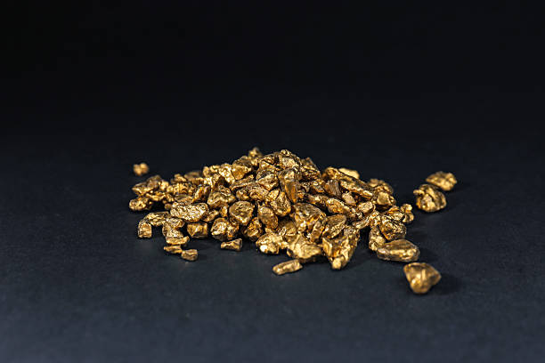 istock Shiny gold nuggets on black table, closeup 2244738596