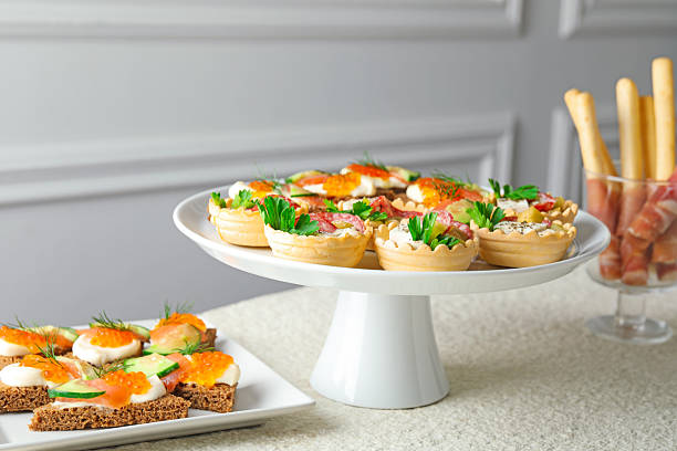 Many different tasty canapes on white table