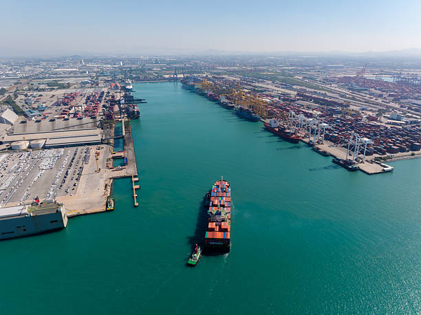 istock containers ship sailed into commercial port for load and unloading cargo from container ship for import export by crane for distributing goods by trailers transported to customers and dealers, 2244740541