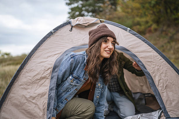 Young couple sharing a joyful moment inside a tent, expressing happiness and connection while experiencing outdoor camping and an adventurous lifestyle together