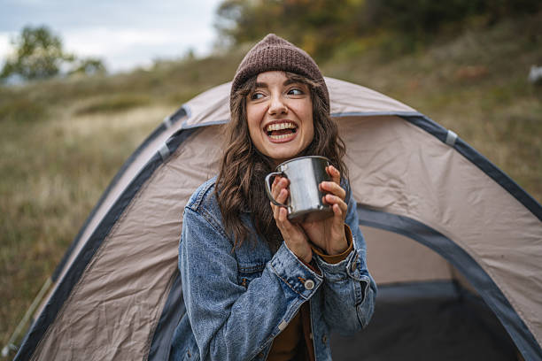 istock Happy woman drinking hot beverage during camping trip 2244742706