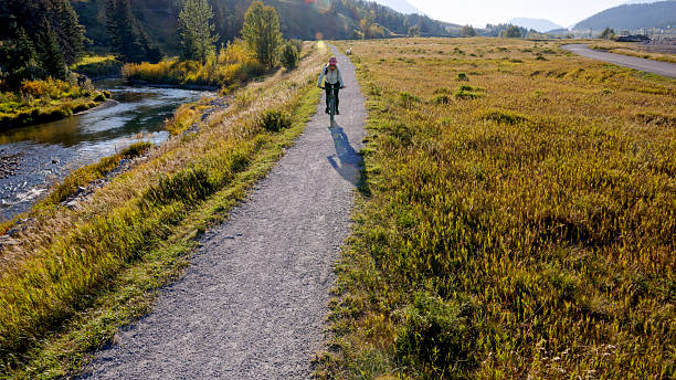 istock Woman rides electric bicycle along pathway above river 2244742922