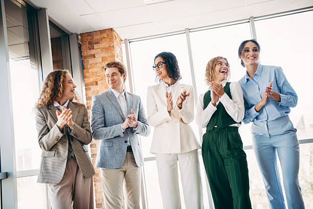 istock Group of professionals clapping together during a meeting in a modern office space, teamwork and celebration concept 2244743809