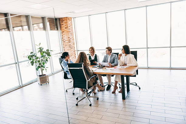 istock Business team collaborating around a table in a modern office workspace with natural lighting, discussing project ideas and strategies 2244743900